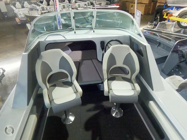 interior of a modern boat with two swivel seats, a windshield, and a spacious front area designed for comfort and functionality